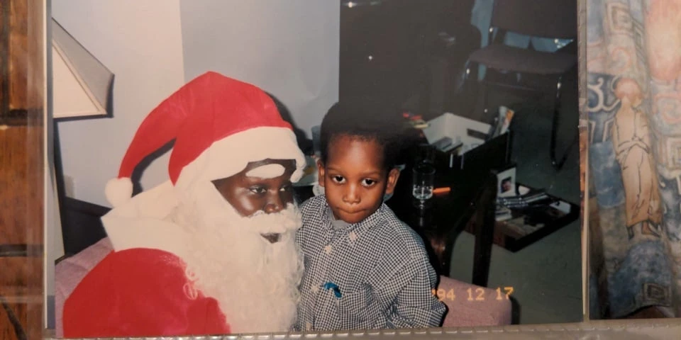 Ali, le frère de Khadi, sur les genoux du « père Noël » incarné par leur maman.