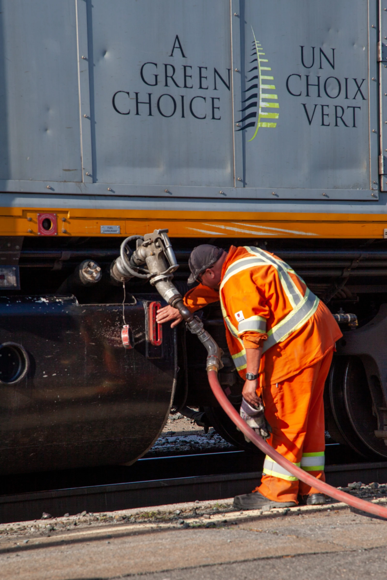 Un employé remplit le réservoir de la locomotive. / Photo : Noé Girard-Blanc