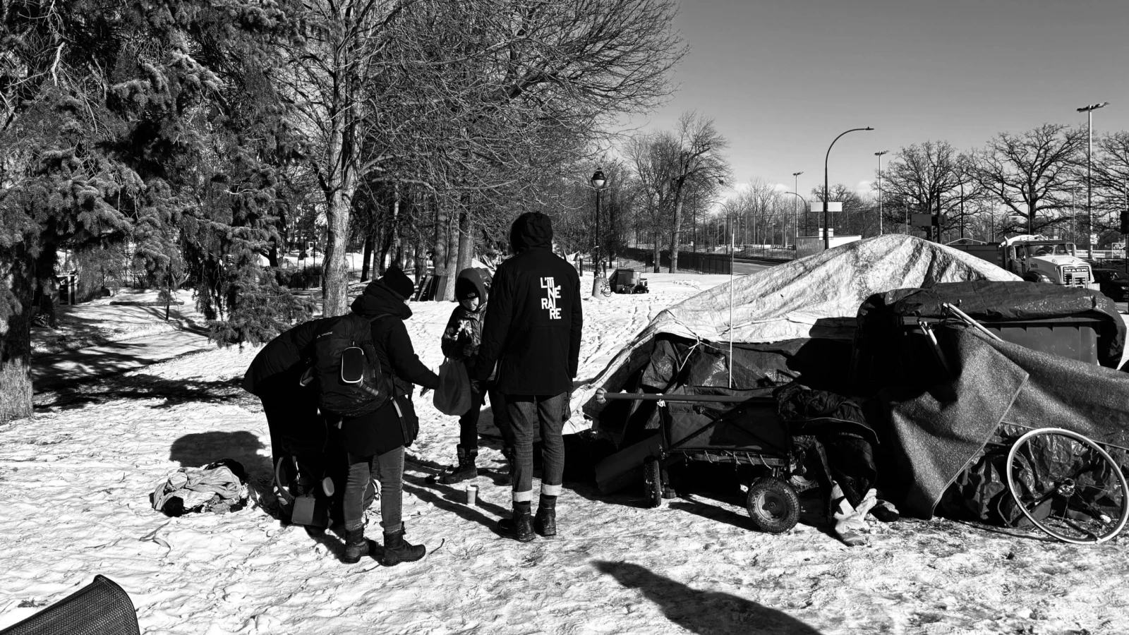 Trois intervenants de L’Itinéraire distribuent café, nourriture, et chauffe-main au campement Notre-Dame.