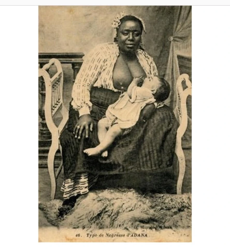 Une carte postale provenant de Turquie et datant de 1910 où on voit une femme noire allaiter un enfant blanc.